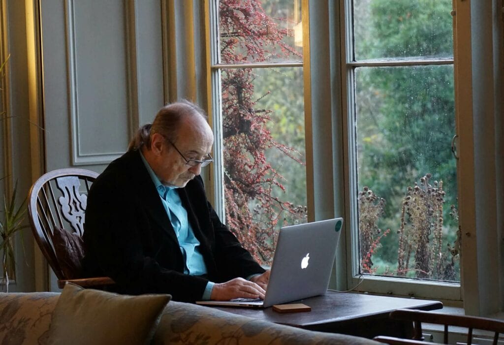Ältere Person, die vor einem Laptop sitzt